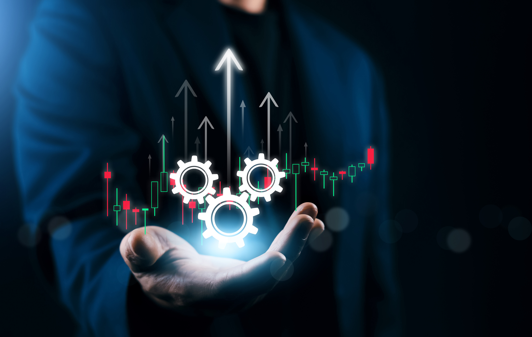 Business automation concept with glowing gear icons and rising financial chart above businessman hand, process optimization, workflow efficiency, growth strategy, fintech analytics.